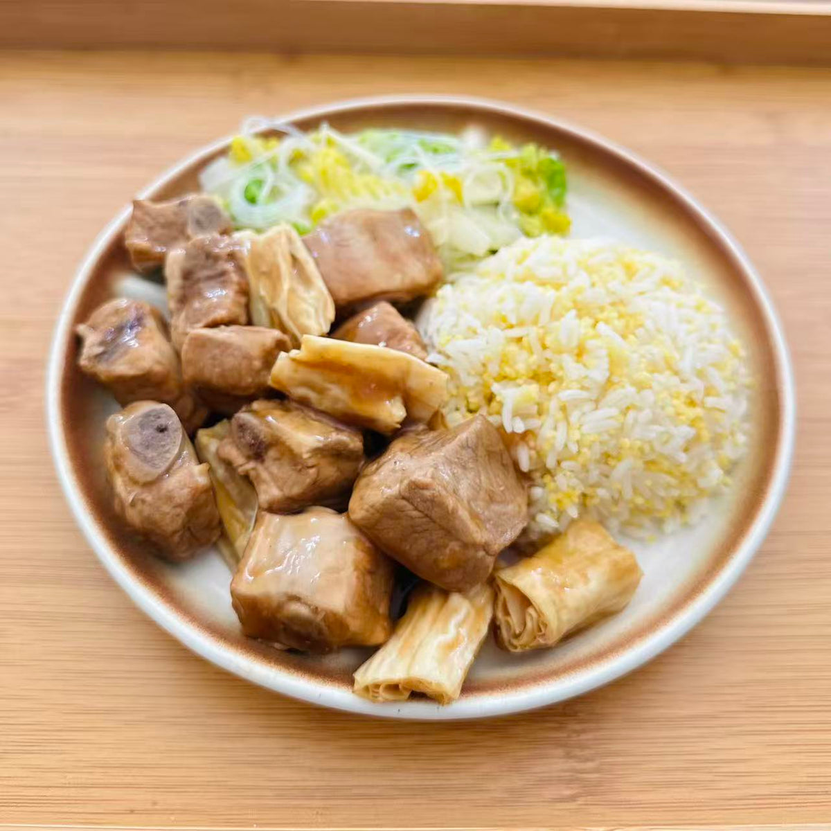 Braised Pork Ribs with Bean Curd Sticks with mixed rice and vegetables in a meal container.