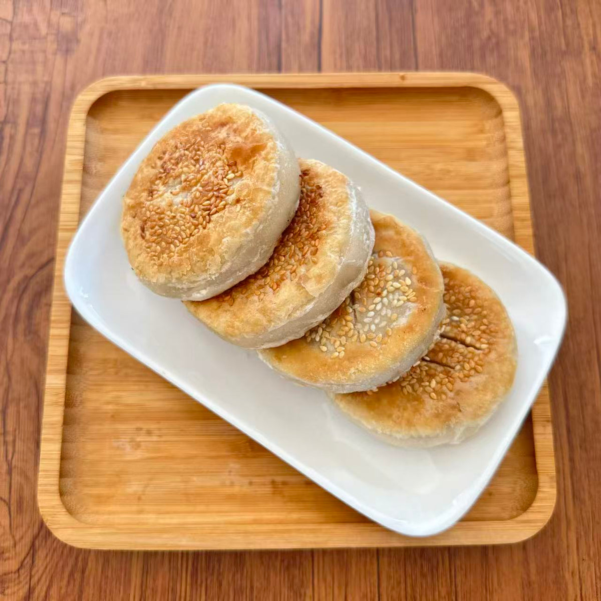 Four pan-fried taro paste cakes served on a white plate